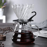 Kit V60 MUVNA con dripper de vidrio y jarra decantadora de 600ml, granos de café al lado