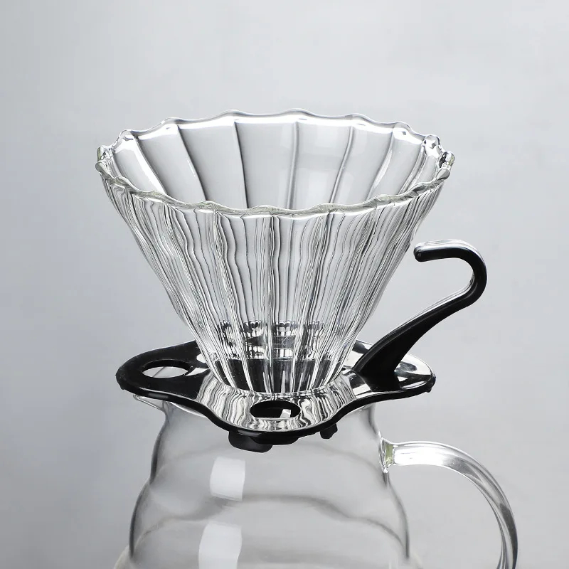 Dripper V60 de vidrio acanalado sobre la jarra decantadora, vista frontal en fondo gris